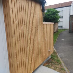 habillage d'un local de jardin collaboratif. Bardage Douglas naturel